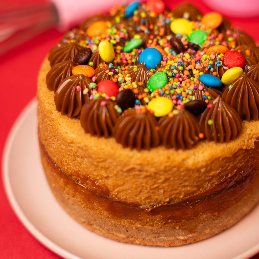 Torta de cumpleaños de Detallitos de Amor decorada con chocolate y grageas de colores
