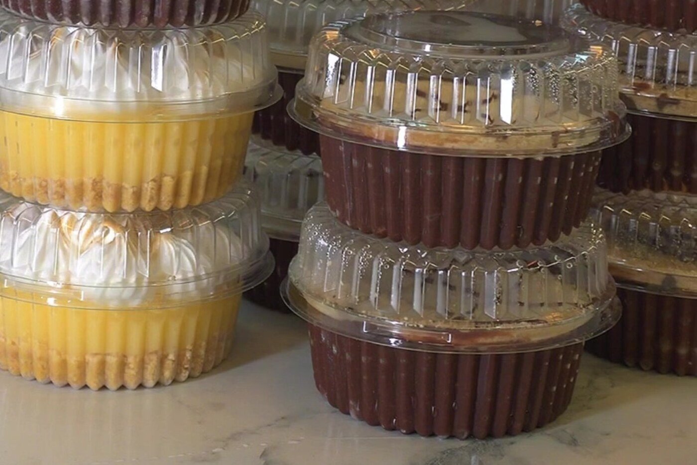 Postres de 6 onzas de Detallitos de Amor apilados y sellados, listos para venta al mayor